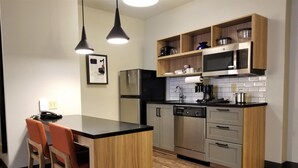 A modern kitchen with a wooden island, built-in appliances, and pendant lighting.
