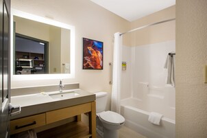 Un baño moderno con lavamanos, inodoro y ducha.
