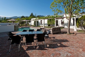 Uma área de pátio com piscina, mobiliário de exterior e vista para as montanhas.