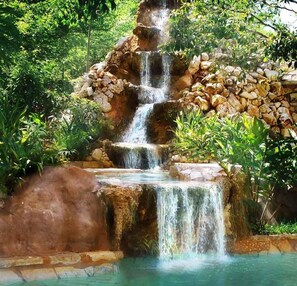 A multi-tiered waterfall in a lush, green setting.