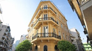 A multi-story building with balconies, arched windows, and a street view. - Athens Lotus Hotel (Athens)