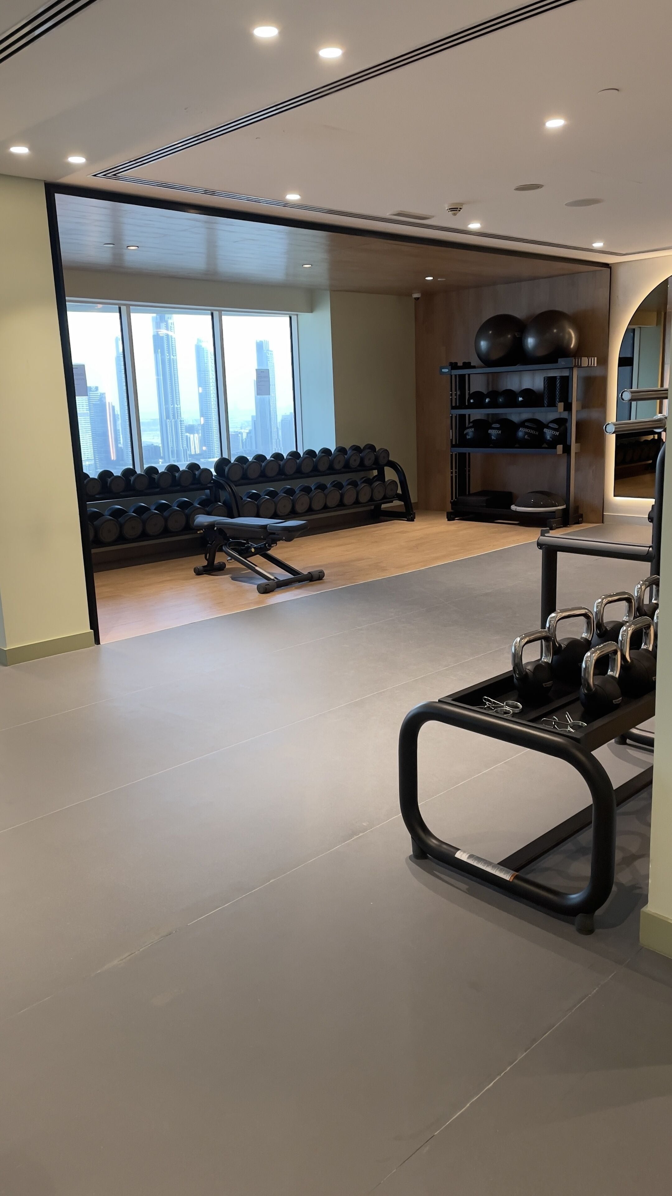 A modern gym with a variety of equipment including dumbbells, kettlebells, and exercise balls.