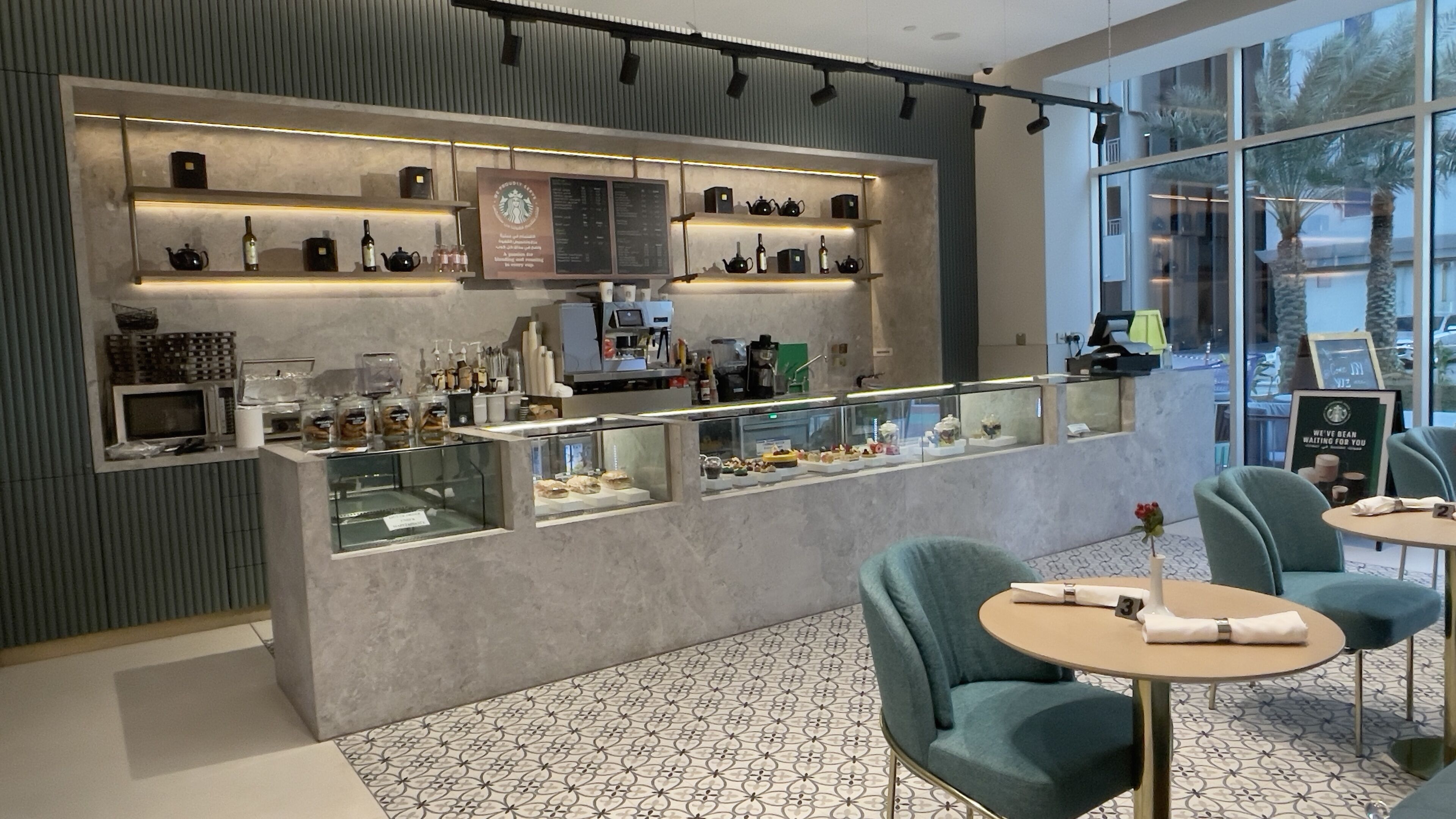 A modern cafe with a bar area, seating, and a menu board.
