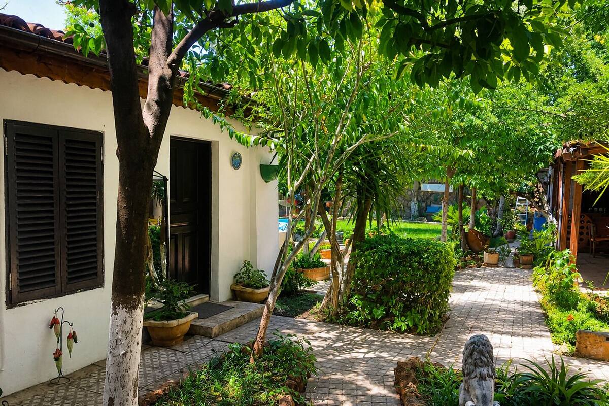 A garden pathway leading to a building with a door and windows.