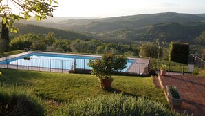 Una piscina con vistas a colinas onduladas al fondo.