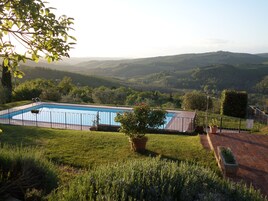 Una piscina con vistas a colinas onduladas al fondo.
