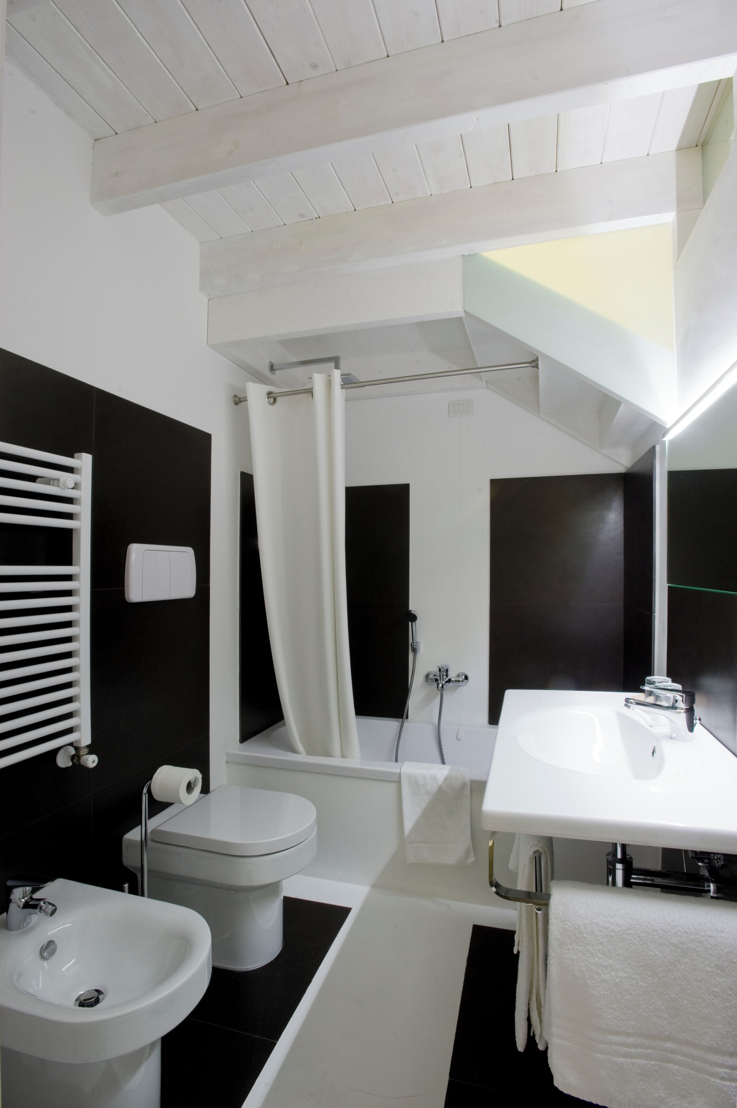 A modern bathroom with a white sink, toilet, and bathtub.