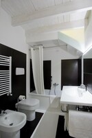A modern bathroom with a white sink, toilet, and bathtub.