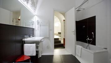 Un bagno moderno con uno specchio grande, una vasca da bagno e una doccia.