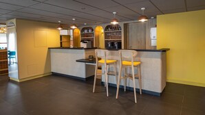 A modern bar area with a counter, stools, and overhead pendant lighting. - Sure Hotel by Best Western Nantes Saint-Herblain (Saint-Herblain)