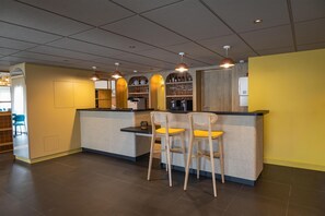 A modern bar area with a counter, stools, and overhead pendant lighting. - Sure Hotel by Best Western Nantes Saint-Herblain (Saint-Herblain)