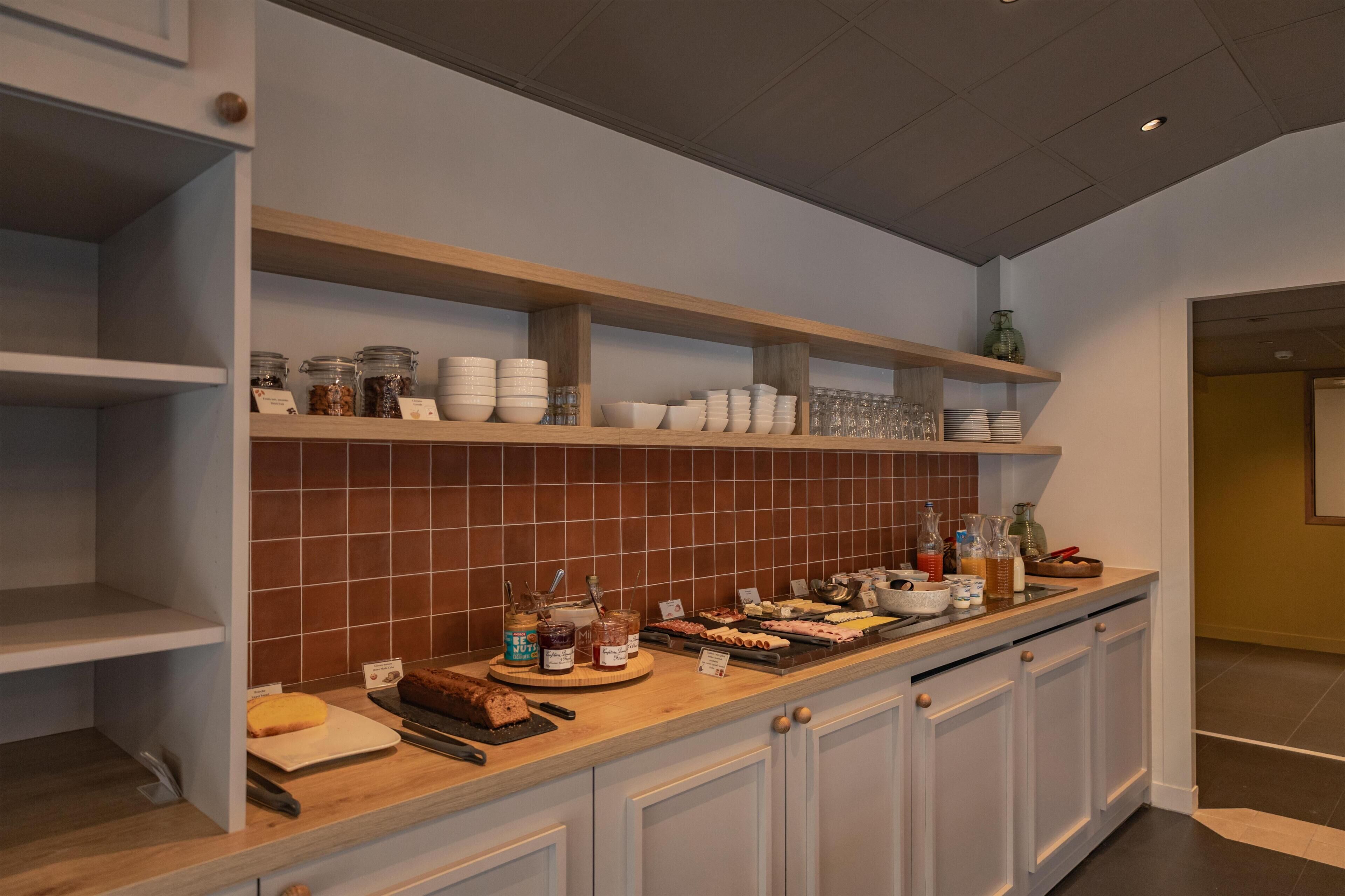 A kitchen with white cabinets, a wooden countertop, and shelves with jars and bowls.