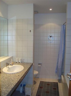 A bathroom with a sink, toilet, and shower.