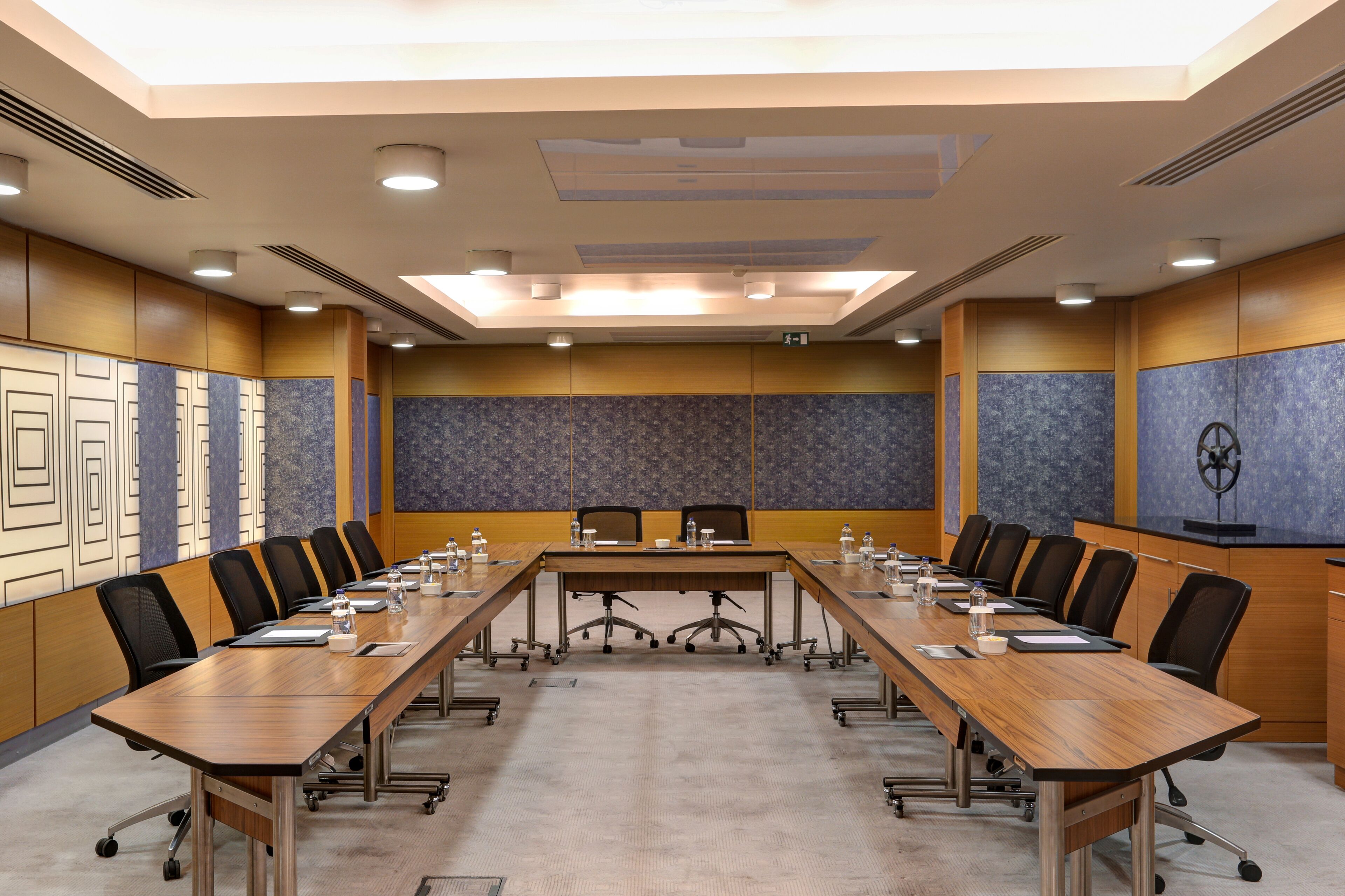 A conference room with a long table, chairs, and a projector screen.