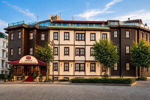 A multi-story hotel with a prominent entrance, a sign for 'GLK Premier The Home Suites & Spa,' and a paved courtyard. - GLK PREMIER The Home Suites & Spa - Boutique Class (Istanbul)