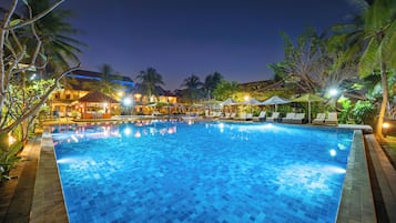 Una piscina al aire libre, sombrillas, sillones reclinables de piscina