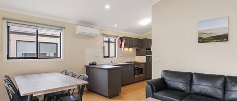 Un apartamento moderno con comedor, cocina y sala de estar.