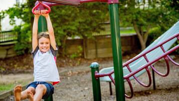A child hanging from a playground structure.