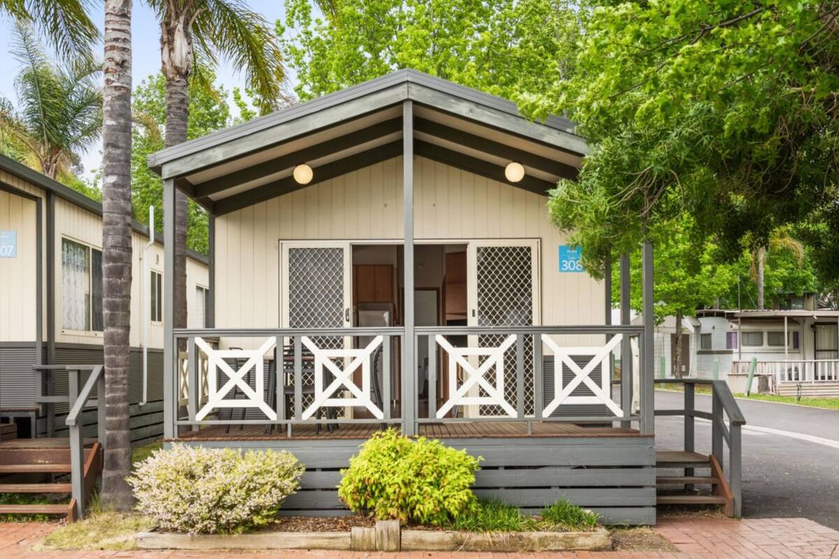 A small, single-story building with a porch and a fenced area.