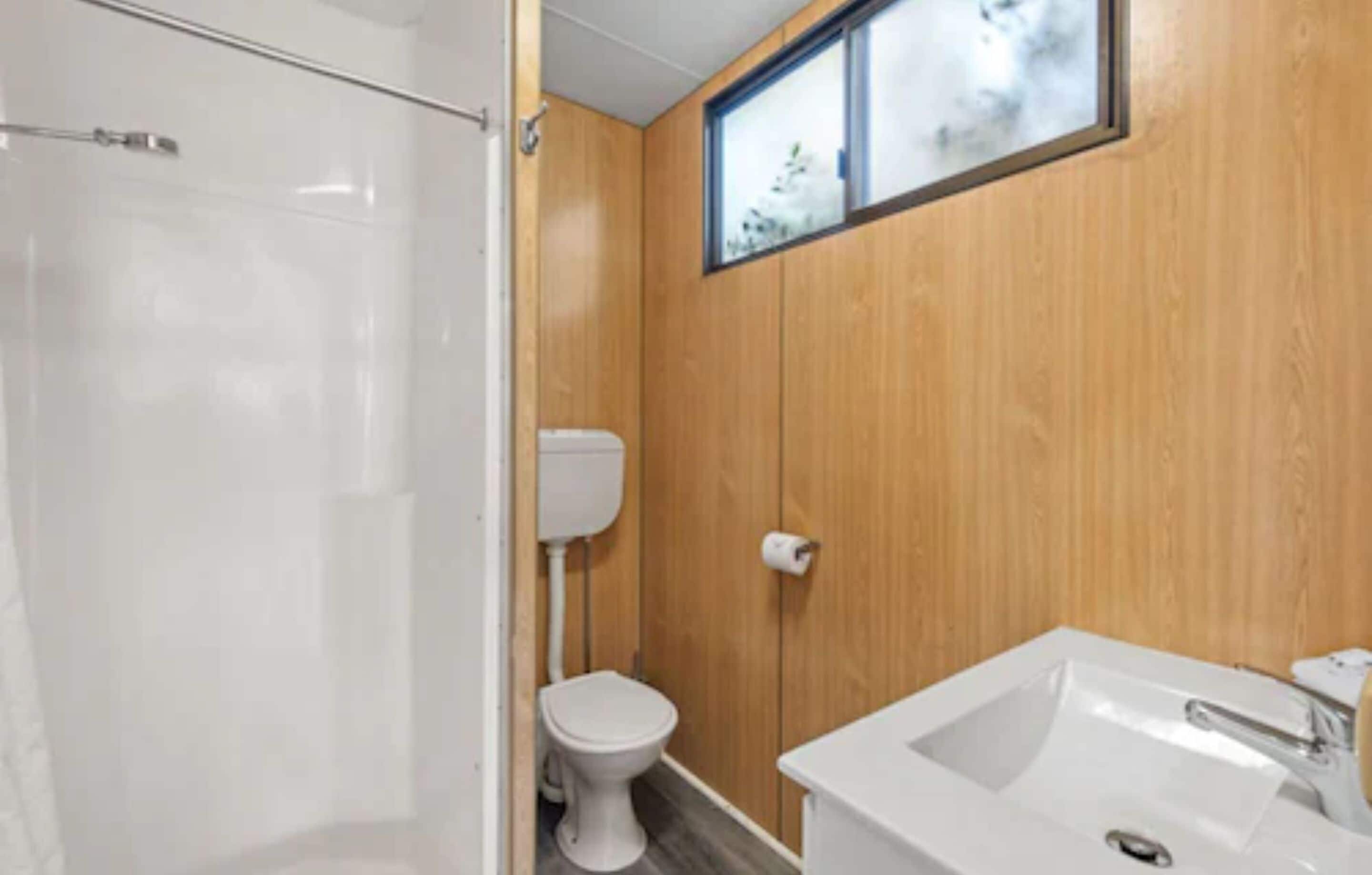 A bathroom with a shower, toilet, and sink.