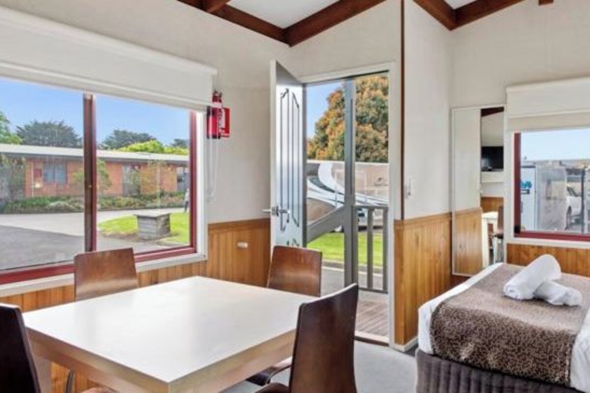Une chambre d’hôtel comprenant un coin repas, un lit et une vue sur l’extérieur.