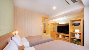A hotel room with two beds, a TV, a wooden cabinet, and a bathroom visible through an open door. - Candeo Hotels Uenokoen (Tokyo)