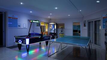 Enjoy games and entertainment in this room featuring a billiards table, ping pong table, and access to a theatre room and pool.