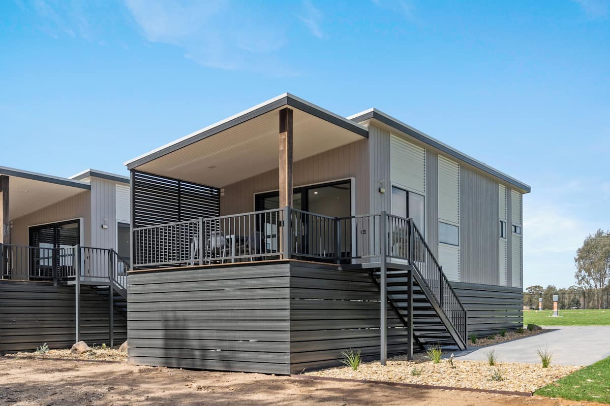 A modern building with a covered outdoor area, a staircase, and a flat roof.