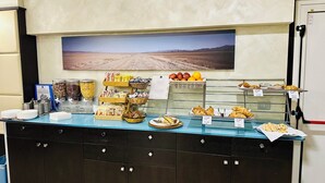 Un bufé de desayuno con diversas opciones de comida y una estación de postres.