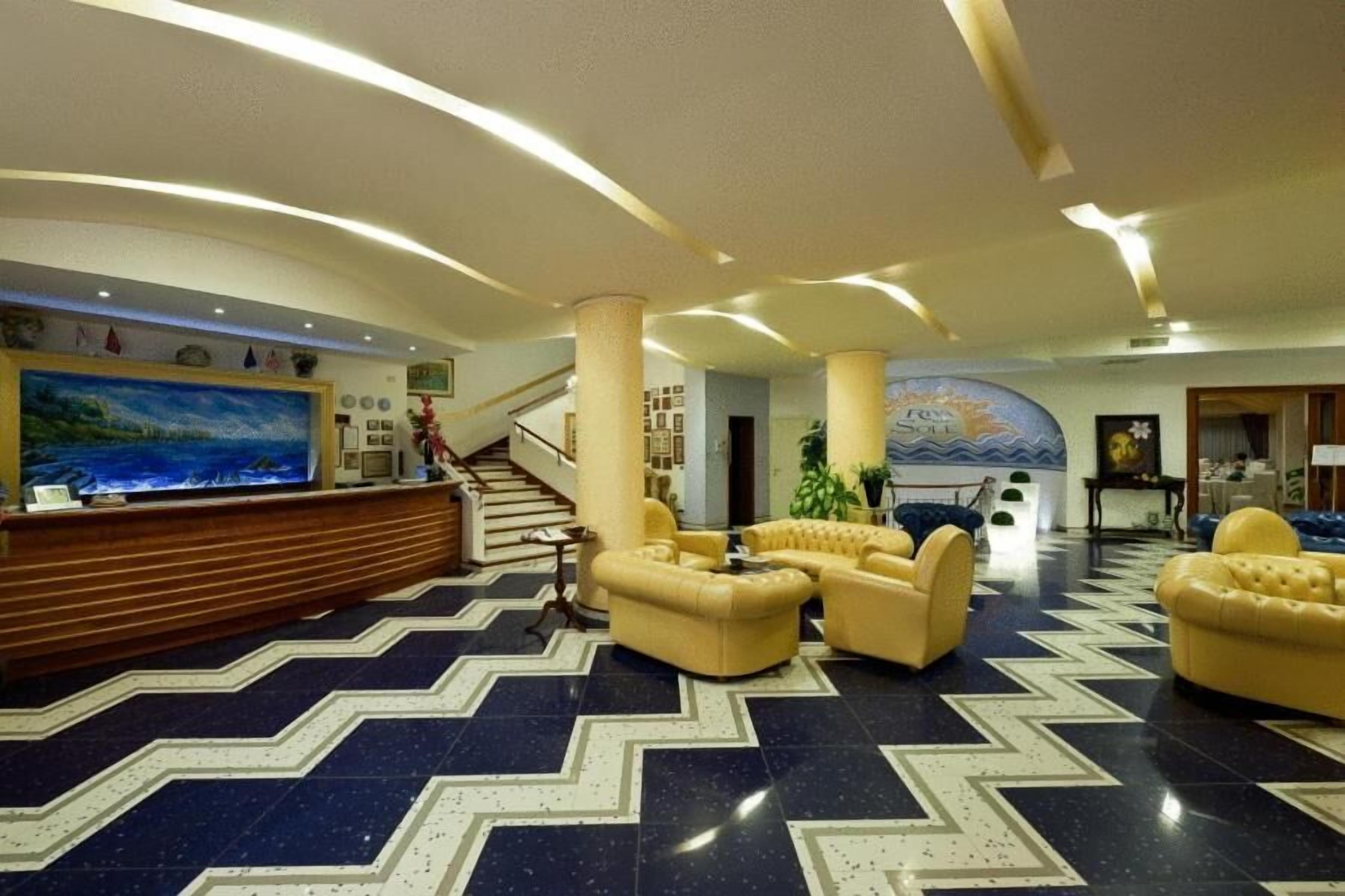 Un hall d’entrée avec un comptoir de réception, un espace salon et un escalier.