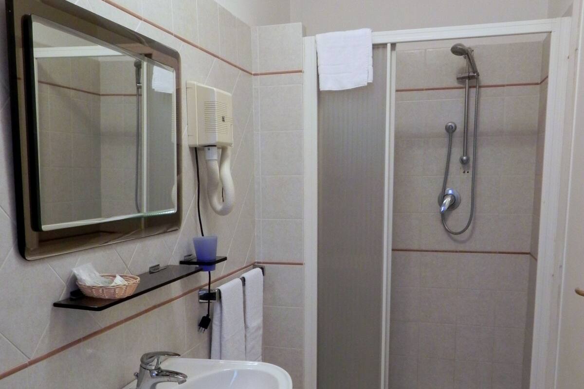 Une salle de bain avec un lavabo, un miroir et une douche.