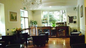 A spacious room with a bar area, seating arrangements, and large windows providing natural light. - Villa Robinia (Genzano di Roma)