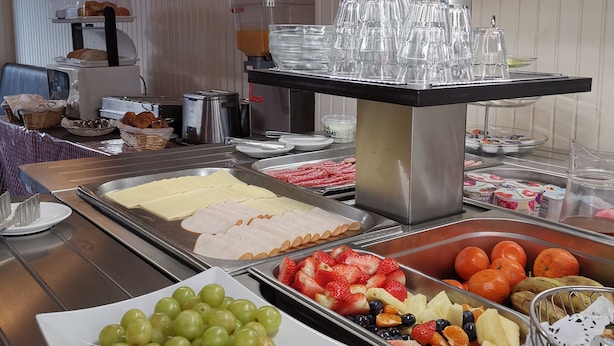 Noutopöydässä on tarjolla monenlaista ruokaa, kuten viinirypäleitä, mansikoita, appelsiineja ja juustoa.