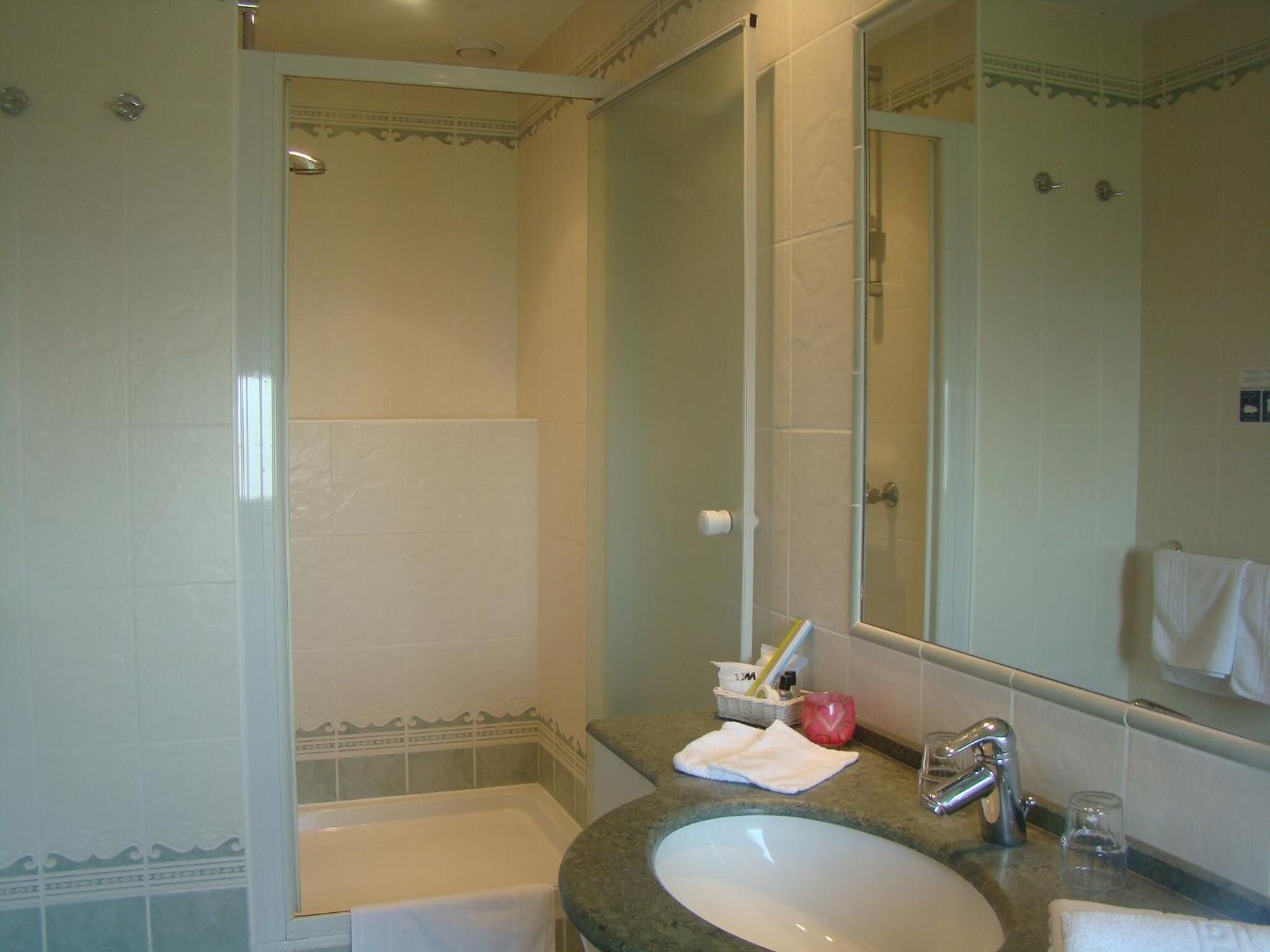 Une salle de bain avec une baignoire, un lavabo et un grand miroir.