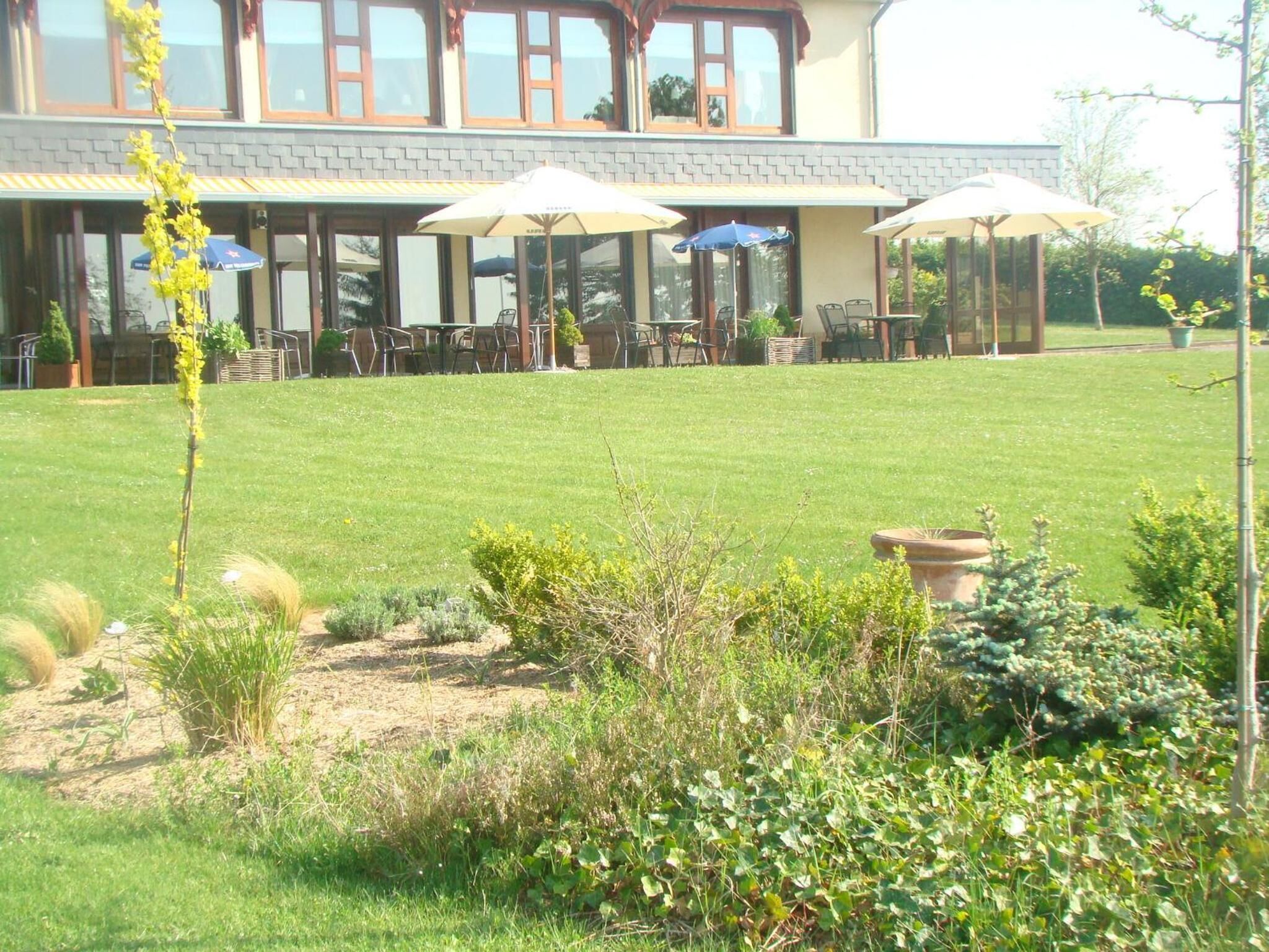 A building with a patio area featuring outdoor seating and umbrellas.