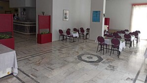 A spacious dining area with marble flooring, multiple tables set with chairs, and a high ceiling with recessed lighting. - Dias (Kusadasi)