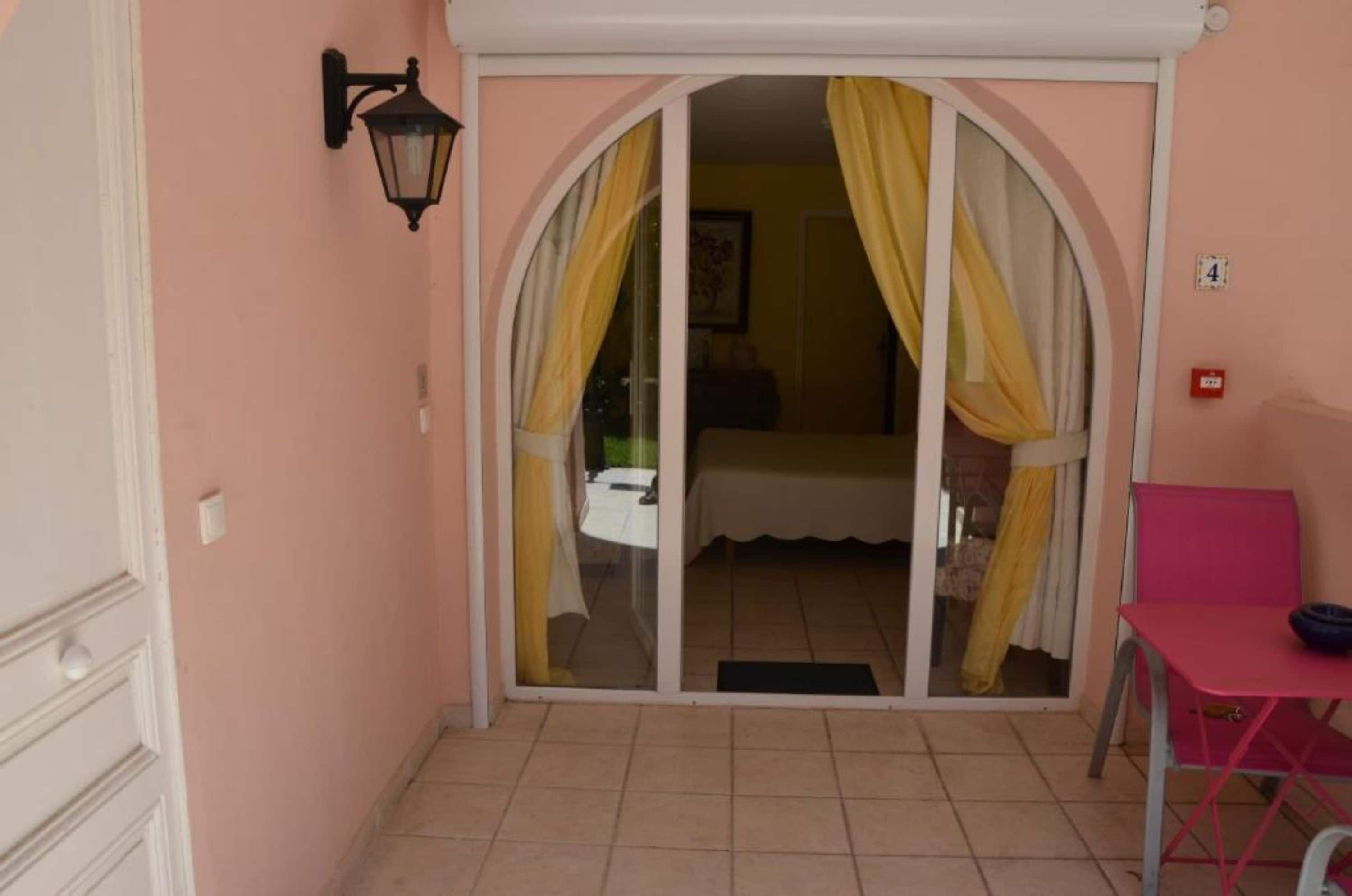 A room with a sliding glass door leading to a balcony, a small table, and a chair.