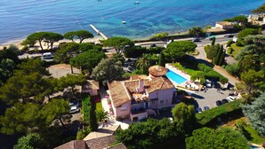 A coastal property with a swimming pool, a beach, and a road leading to the sea. - Hôtel Villa des Anges (Grimaud)