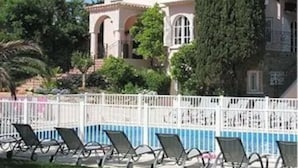 A large building with a pool, surrounded by a white fence. - Hôtel Villa des Anges (Grimaud)
