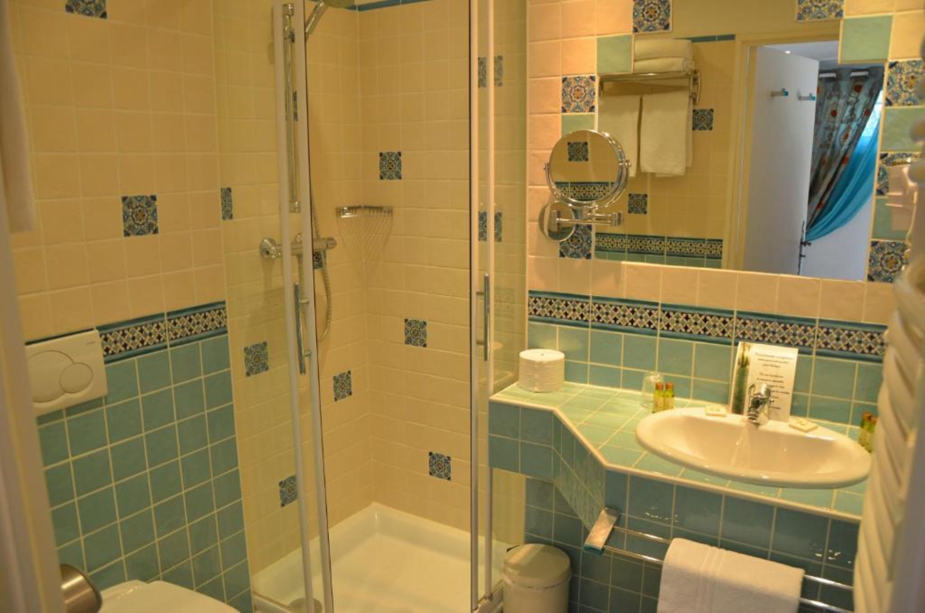 Une salle de bain équipée d’une douche, de toilettes, d’un lavabo et d’un miroir.