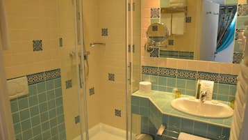 Une salle de bain équipée d’une douche, de toilettes, d’un lavabo et d’un miroir.