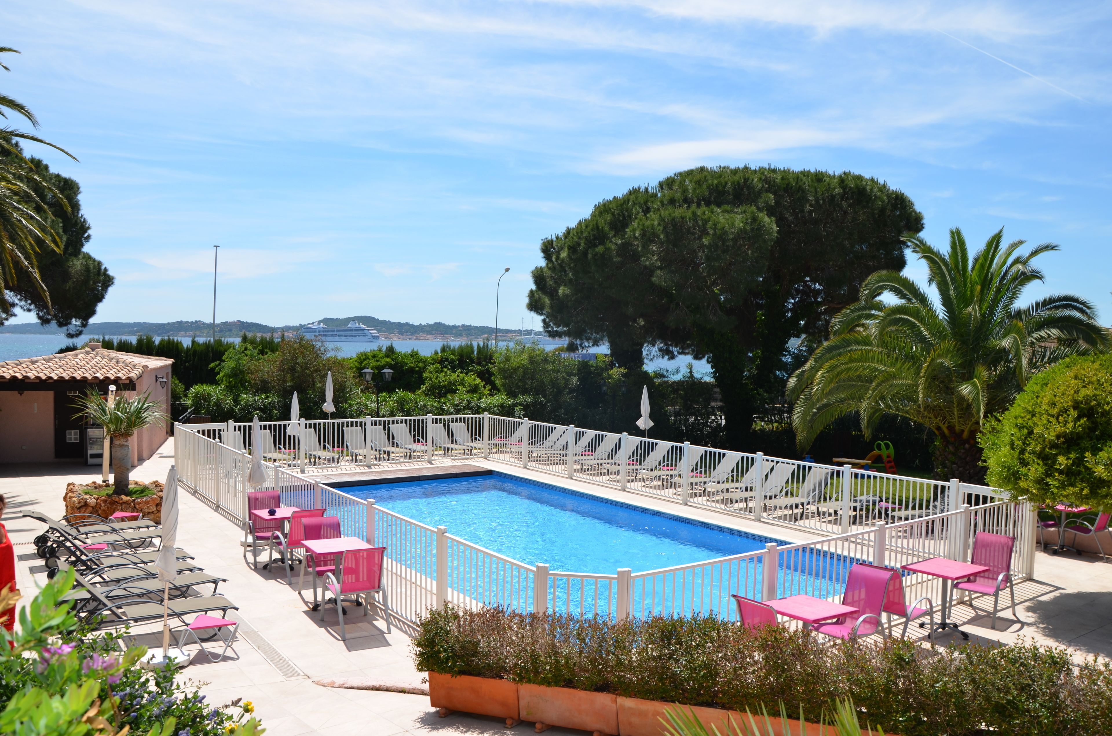 Una piscina al aire libre de temporada, sombrillas, tumbonas