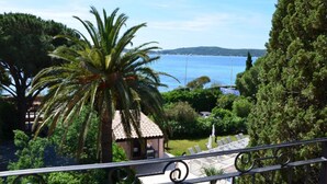 A coastal view with a palm tree, a small building, and a clear sky. - Hôtel Villa des Anges (Grimaud)