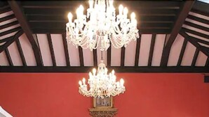 A bar area with wicker chairs, a chandelier, and a mirror reflecting the bar. - Hôtel Villa des Anges (Grimaud)