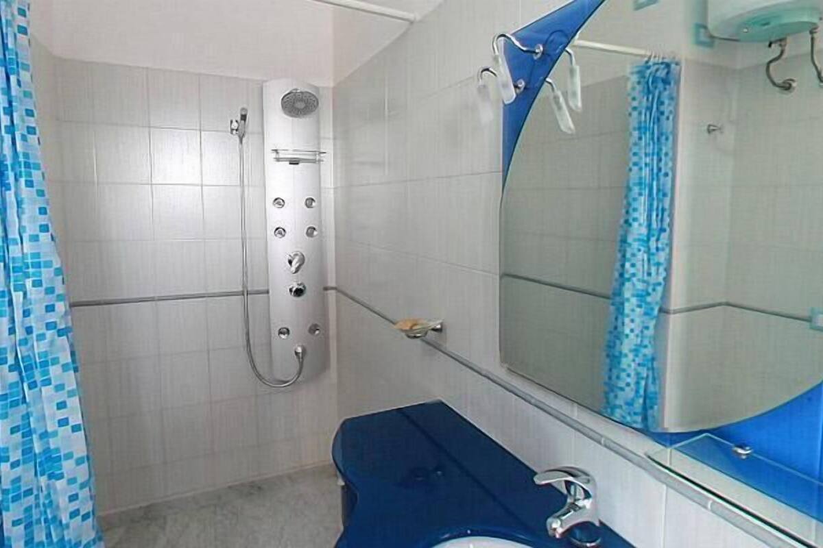 A bathroom with a shower, a sink, and a mirror.