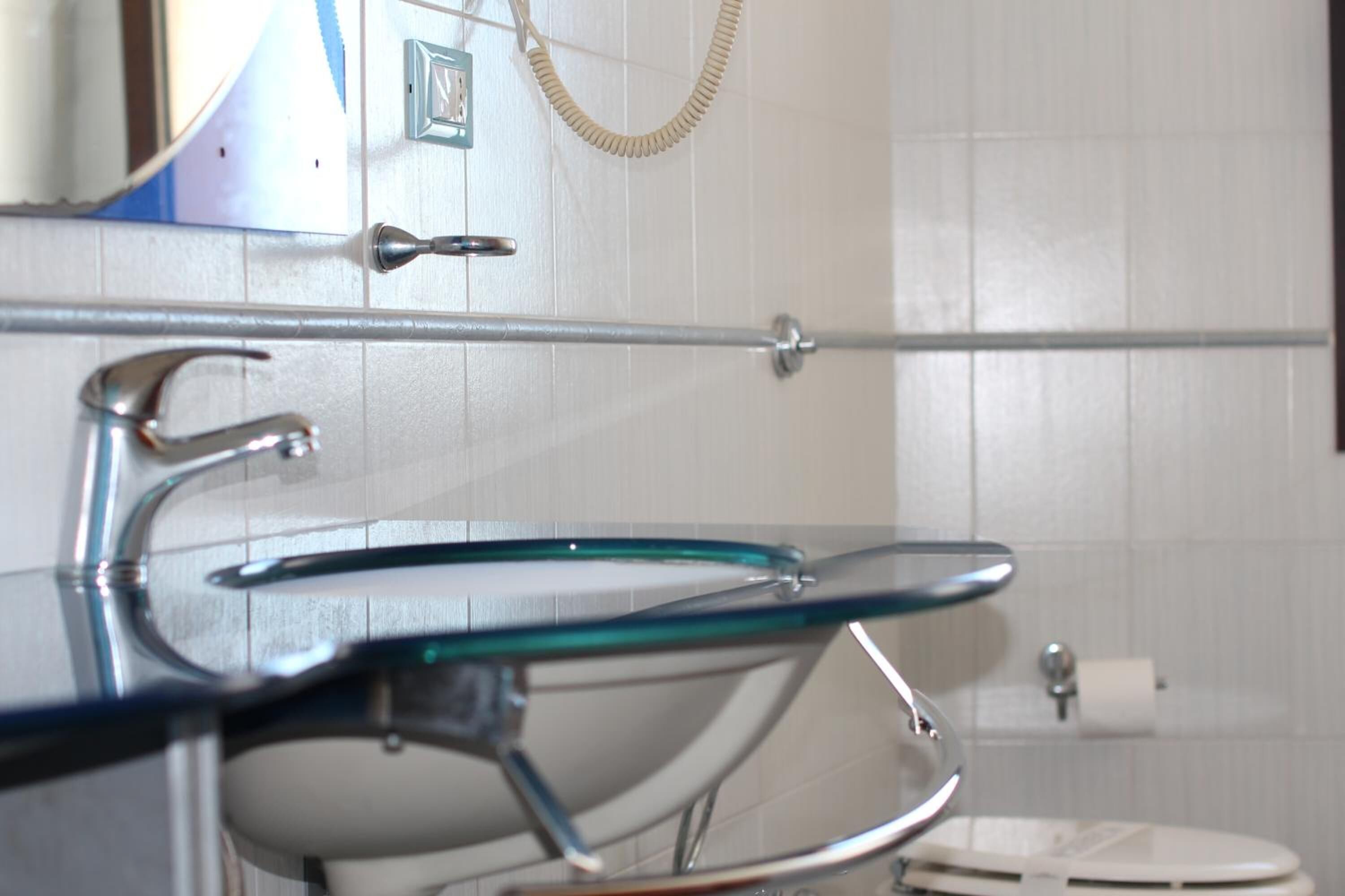 Een badkamer met een douchecabine van glas, een wit toilet en een handdoekrek.