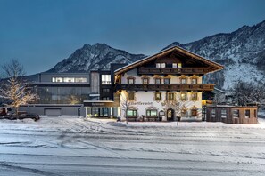 A hotel with a modern building and a traditional chalet-style structure, both with visible signage.