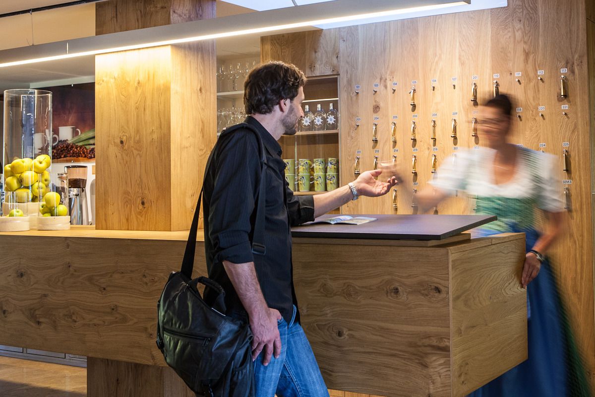 Un comptoir d’accueil en bois, doté d’un présentoir pour exposer des bouteilles de vin.