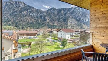 Un interior de madera con un amplio ventanal que da a una zona residencial y montañas.