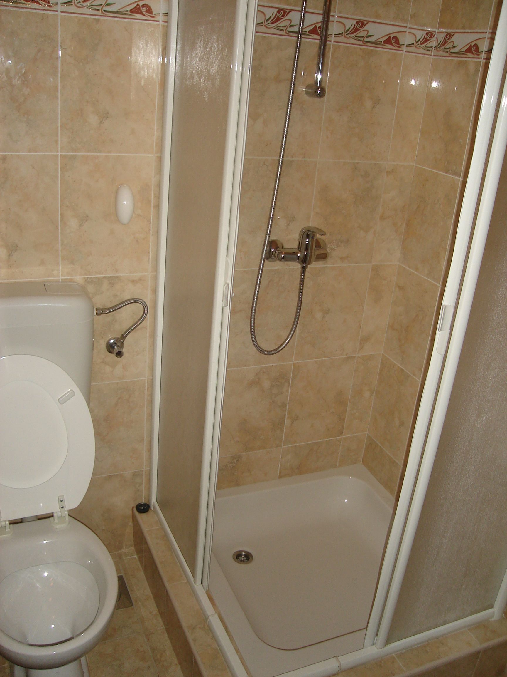 A bathroom with a toilet, a shower stall, and a sink.